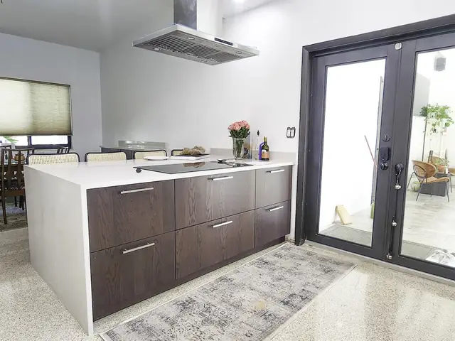 White kitchen with a walnut island and French doors