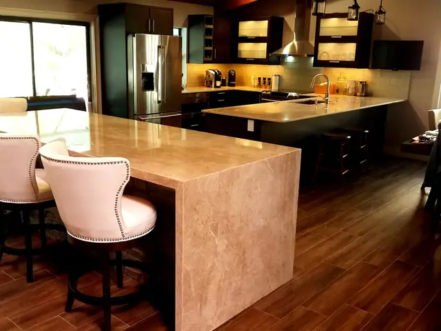 Dark wood kitchen with a stone waterfall island