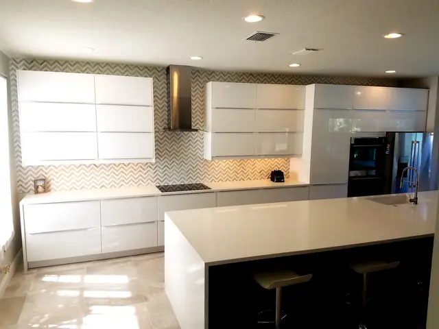Glossy white kitchen with a chevron backsplash