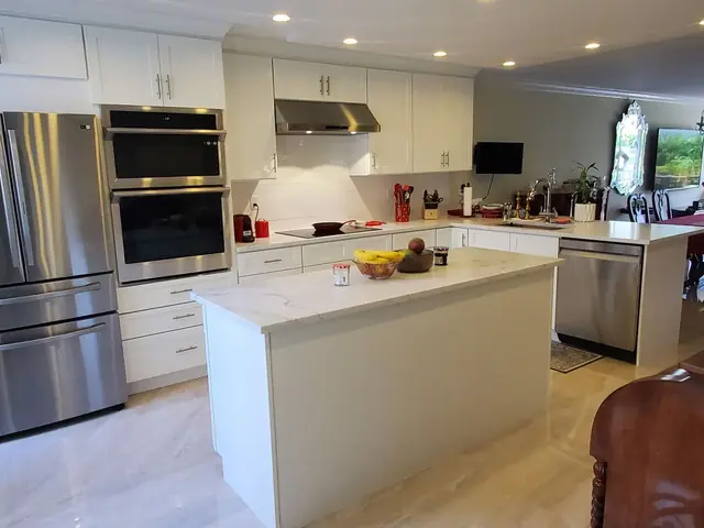 White kitchen with an island and stainless appliances