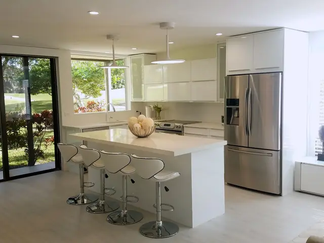 White kitchen with an island and garden view