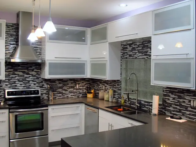 White IKEA kitchen with frosted glass cabinets and a mosaic backsplash